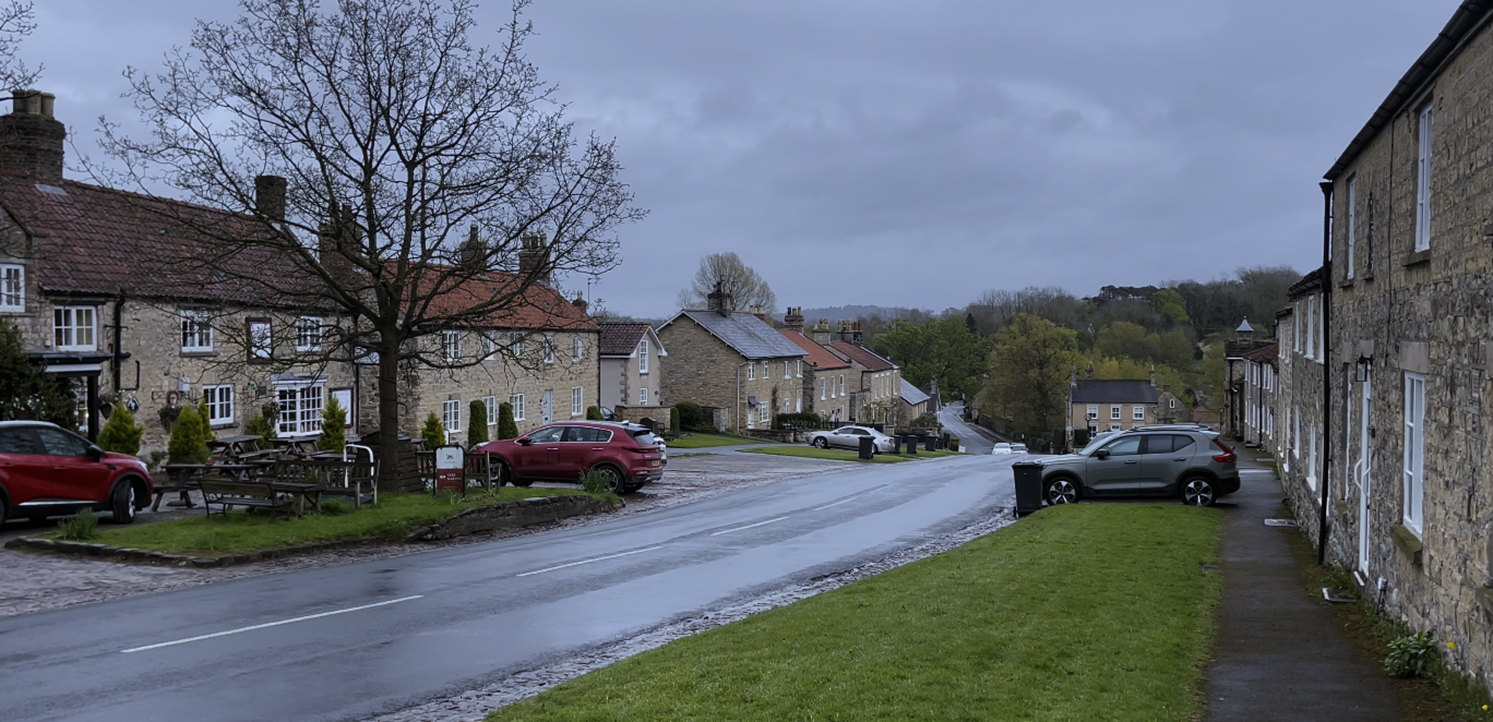 A road with cars parked on it
Description automatically generated